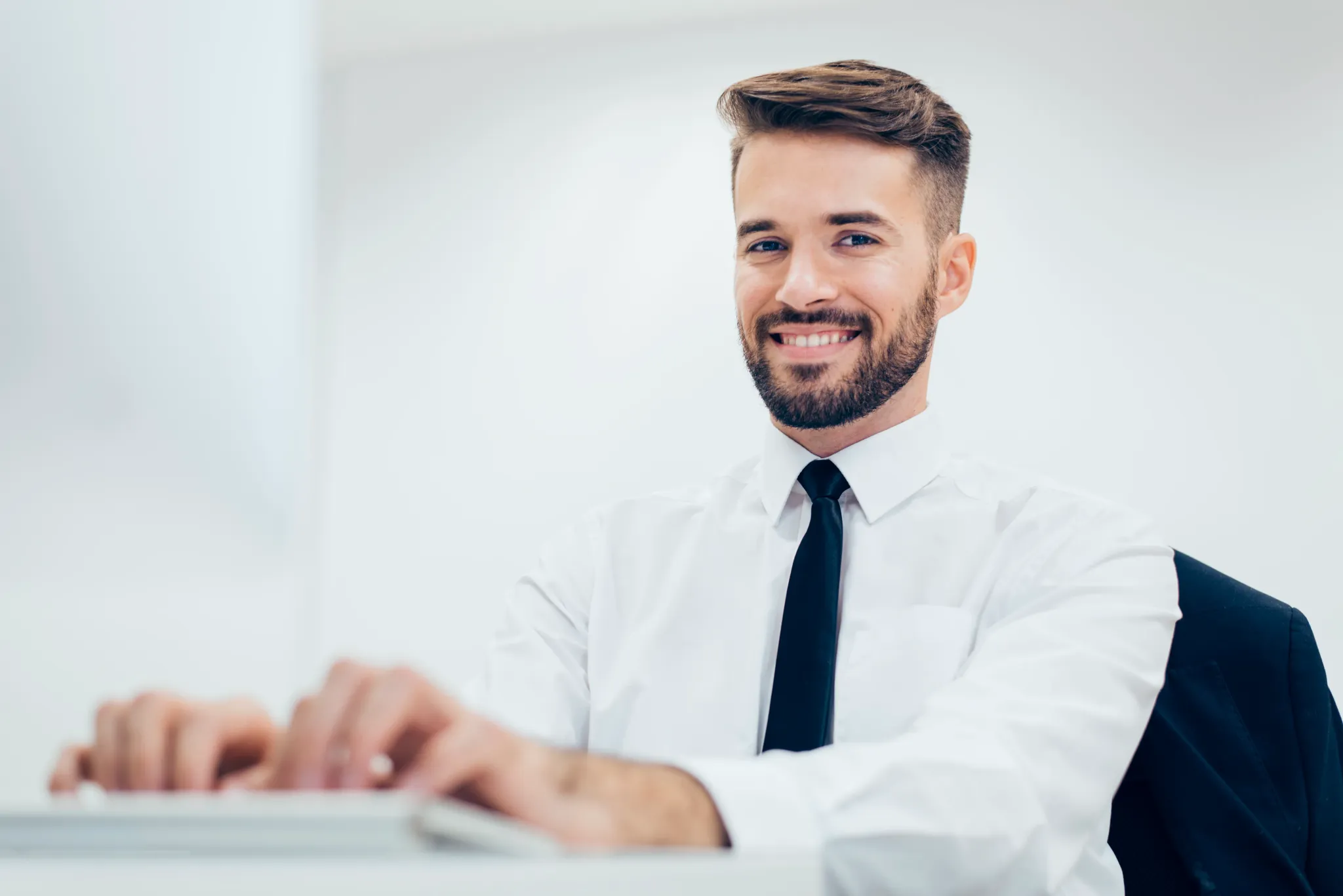 elegant-smiling-man-typing-computer.jpg