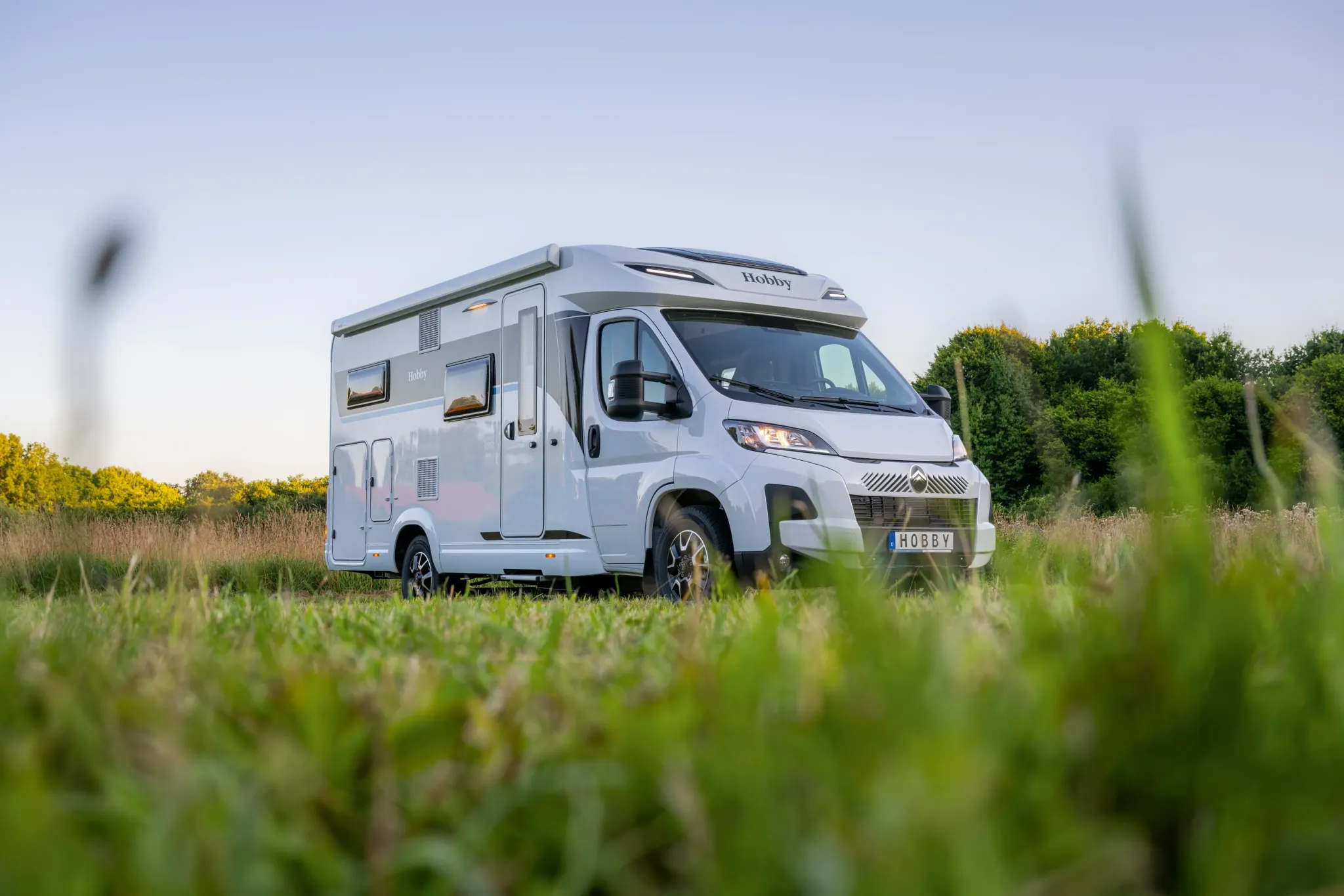 Hobby Wohnmobil auf einer Wiese bei blauem Himmel