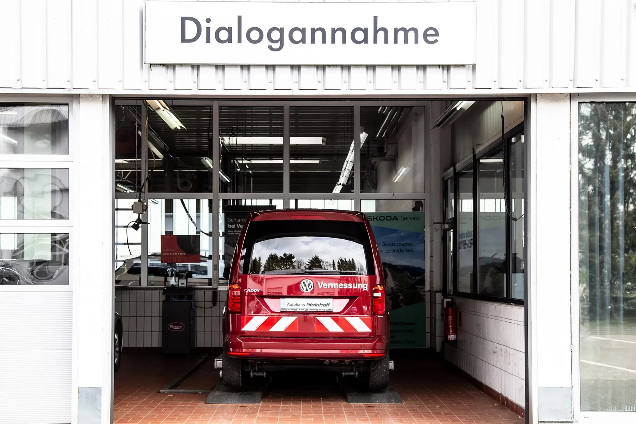 Ein roter VW von hinten steht in der Einfahrt der Dialogannahme des Autohaus Steinhoff